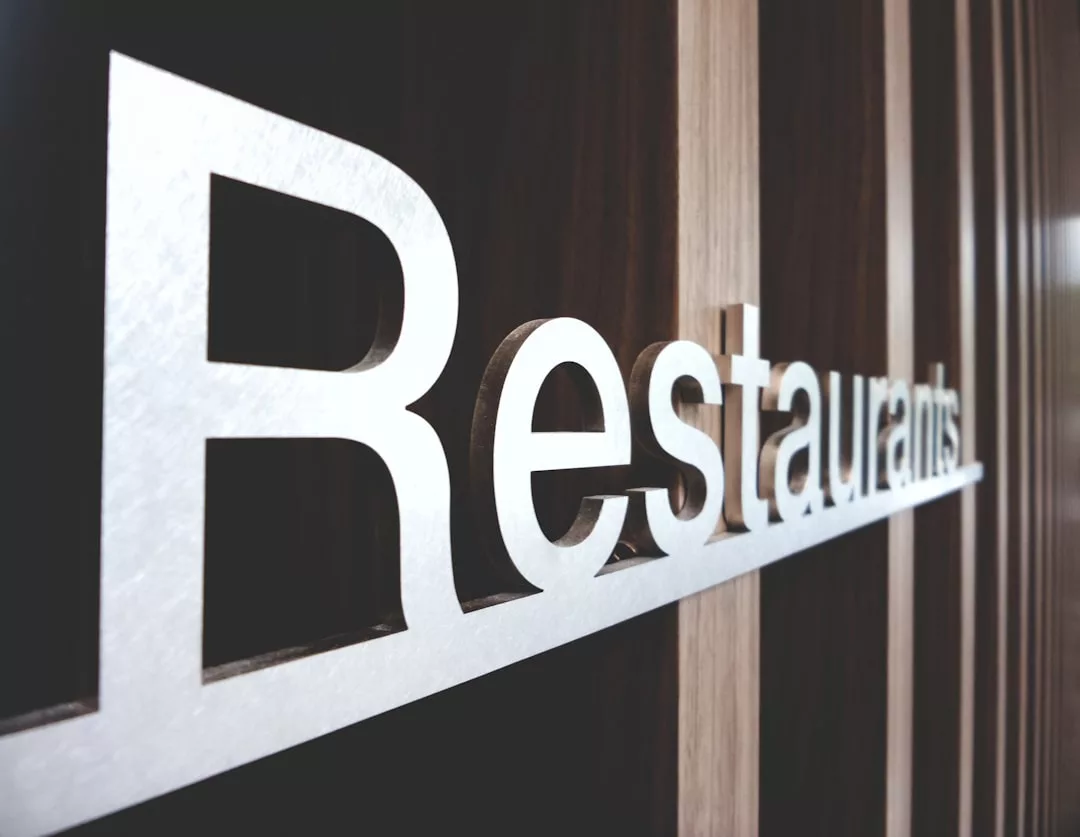 Large, silver letters spelling "Restaurant" on a wooden wall, viewed from a side angle—an inviting touch typical of boutique restaurants in Artà.