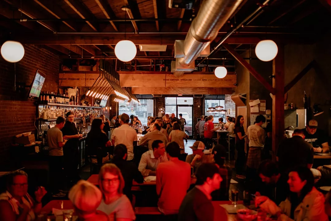 A busy, warmly lit bar and restaurant in Palma de Mallorca, where people gather to eat, drink, and socialize—offering the lively ambiance typical of fine-dining Indian restaurants.