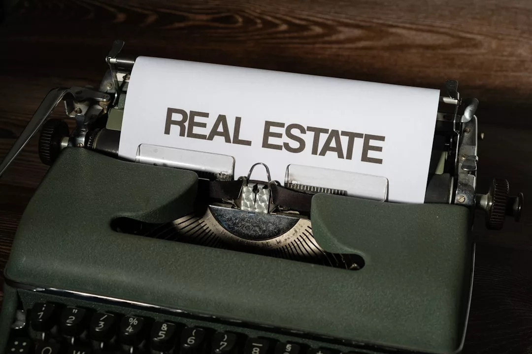 A typewriter with a sheet of paper displaying the words "REAL ESTATE" in bold letters, ideal for drafting a legal checklist when purchasing property in Formentor.