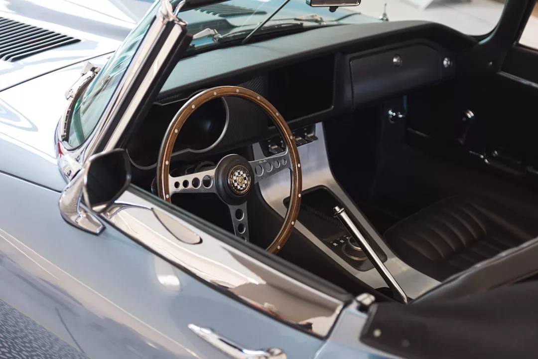 Interior of a classic convertible car with a wooden steering wheel and black leather seats, perfect for cruising through Magaluf’s vibrant entertainment district or arriving in style at luxury commercial spaces.
