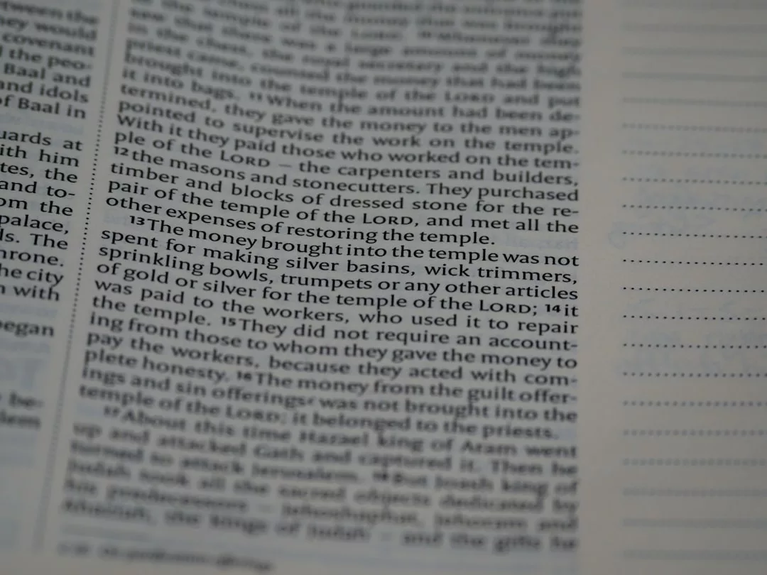 Close-up of a Bible page with a focus on verses about money brought into the temple, offering insight into ancient valuation methods akin to those used in property valuation today.
