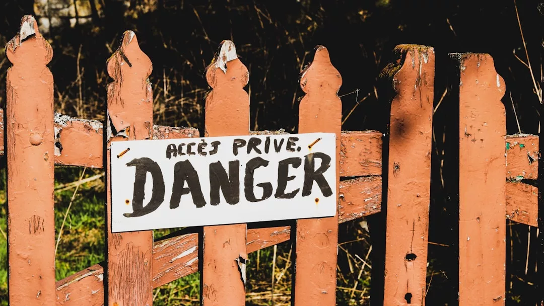 A weathered fence with a sign reading "Accès Privé, Danger" warns of private, dangerous property—reminiscent of the exclusivity found in gated communities like Son Vida, where community fees help ensure privacy and security.