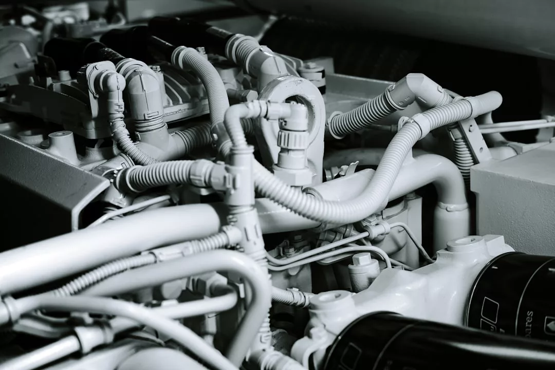 Close-up view of mechanical engine parts and hoses, showing detailed wiring and components in grayscale—ideal for Yacht Charter operators preparing vessels at Cala d’Or Marina.