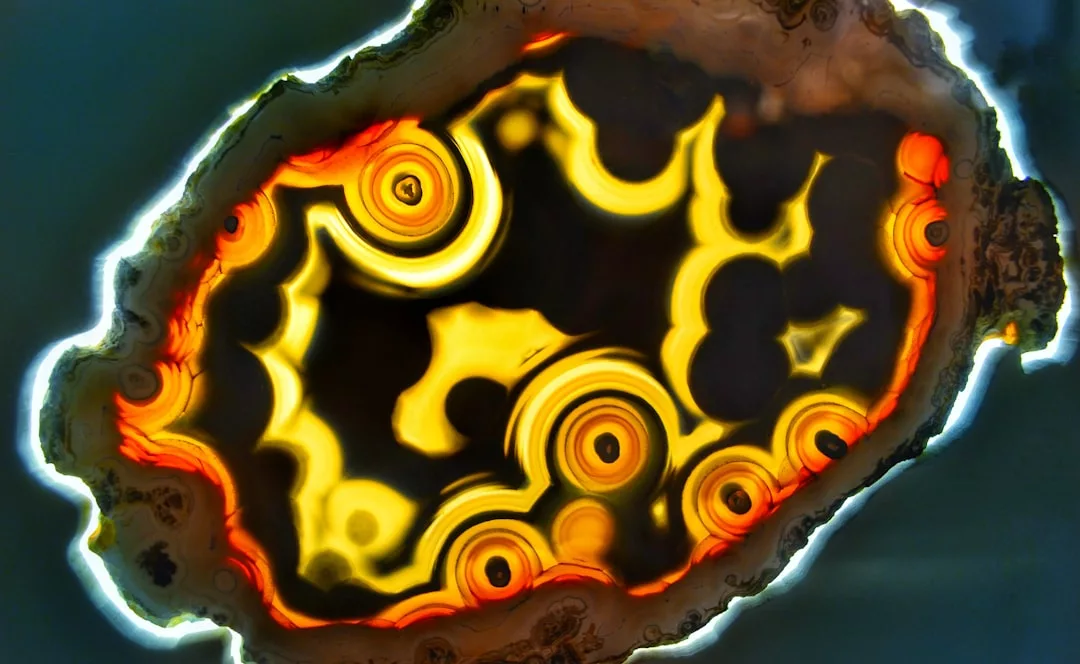 A close-up of a polished geode slice, evoking luxury with its concentric yellow, orange, and brown bands and translucent edge—perfect for adding a touch of Majorca-inspired style to your lifestyle decor.