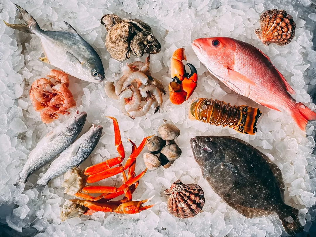 Various fresh seafood including fish, shrimp, crab legs, lobster tail, clams, and scallops arranged on a bed of ice evoke the luxury lifestyle of Majorca’s stunning coastal markets.