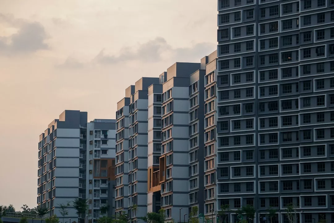 Several modern high-rise apartment buildings stand side by side under a cloudy, overcast sky at sunset, offering a glimpse into luxury lifestyle living reminiscent of Majorca.